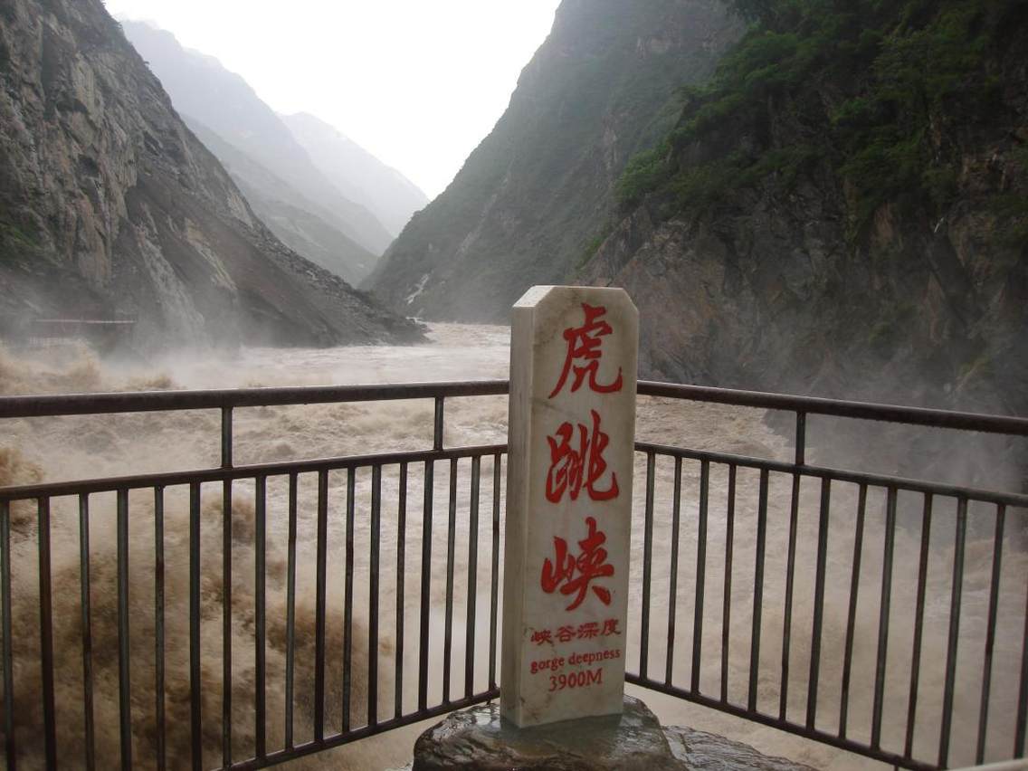 丽江虎跳峡虎跳峡景区地处玉龙县龙蟠乡，地理位置27°10'27"N 100°05'13"E，距丽江城区84公里，为国家AA级景区，主要包括虎跳峡码头经营设施片区、2.6km主栈道游览区两部分。虎跳峡景区地处“三江并流”核心区域，属青藏高原东缘与横断山系结合部位，是重要的新构造活动带，虎跳峡在喜马拉雅造山运动中形成,在构造过程中金沙江南北两岸区域发生断裂,形成断层带,金沙江水沿断裂区域长期淘蚀下切形成了世界上最深的峡谷。虎跳峡栈道景区集“深、险、奇、绝、秀”为一景，南岸是海拔5596米的玉龙雪山，北岸是海拔5396米的哈巴雪山，最大高差3900米，江流最窄处仅20米，传说有虎跃石而过，故名虎跳峡。沿栈道漫步，宛如步入绵延不断的峡谷画卷，峡江水拍，江涛映霞，看江中巨石，如砥柱般直卧中流，把激流中分为二，巨浪滔天，涛声如雷，惊天动地，领略到“万仞绝壁万马奔，一线天盖一线江”的旷世奇观。