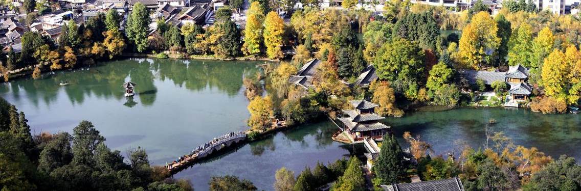 丽江古城，又名“大研镇”，位于中国西南部云南省的丽江市，坐落在丽江坝中部，玉龙雪山下。丽江古城历史悠久，古朴自然，兼有水乡之容、山城之貌。尤其当地古老而神秘的纳西文化，更具吸引世界各地游客的魔力。丽江古城向北约一公里，位于象山之麓，有举世闻名的黑龙潭公园，景区内有龙神祠、得月楼、锁翠桥等著名古建筑掩映在苍翠林木之间，与潭中碧水和玉龙雪山交相辉映，风光绝佳。站上黑龙潭畔的象山之巅，可以眺望玉龙雪山及丽江全景，令人心旷神怡，感叹丽江之大美。