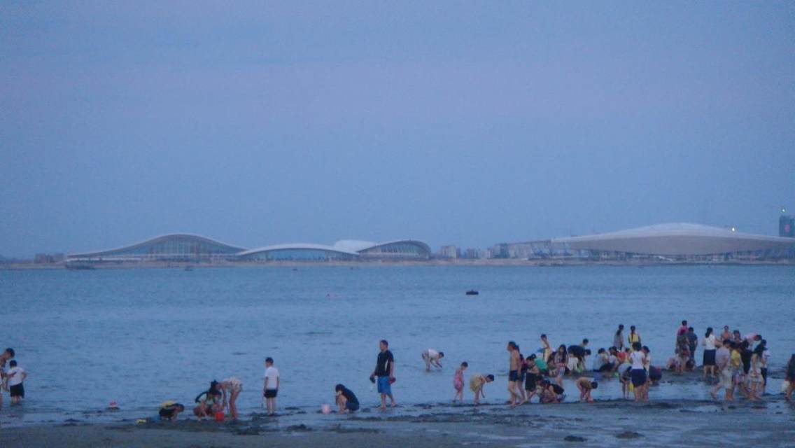 碧海蓝天，在海的那边，隐约可见湛江省运会主会馆。