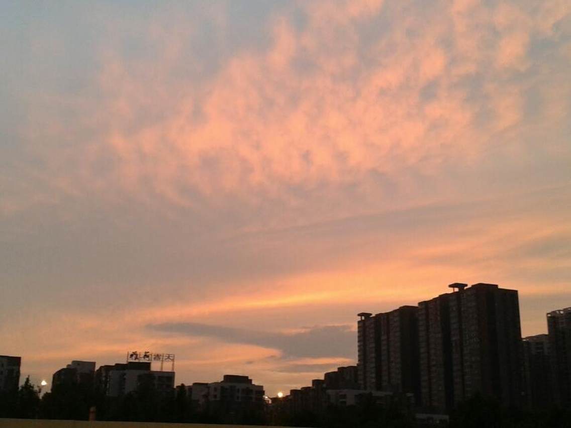 雨后的晚霞，带给人们的是欣喜与如此美景的赞叹，淡淡的橙红并不艳丽，而是带着一股清新的味道，不远处的房屋，或高或低，伫立在这雨后的傍晚，想必是惬意非凡的。