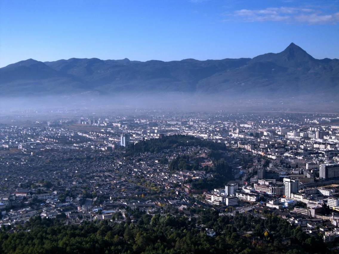 丽江古城，又名“大研镇”，位于中国西南部云南省的丽江市，坐落在丽江坝中部，玉龙雪山下。丽江古城历史悠久，古朴自然，兼有水乡之容、山城之貌。尤其当地古老而神秘的纳西文化，更具吸引世界各地游客的魔力。丽江古城向北约一公里，位于象山之麓，有举世闻名的黑龙潭公园，景区内有龙神祠、得月楼、锁翠桥等著名古建筑掩映在苍翠林木之间，与潭中碧水和玉龙雪山交相辉映，风光绝佳。站上黑龙潭畔的象山之巅，可以眺望玉龙雪山及丽江全景，令人心旷神怡，感叹丽江之大美。