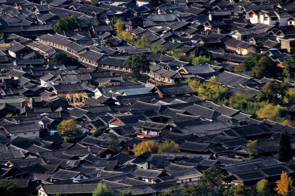 丽江古城，又名“大研镇”，位于中国西南部云南省的丽江市，坐落在丽江坝中部，玉龙雪山下。丽江古城历史悠久，古朴自然，兼有水乡之容、山城之貌。尤其当地古老而神秘的纳西文化，更具吸引世界各地游客的魔力。丽江古城向北约一公里，位于象山之麓，有举世闻名的黑龙潭公园，景区内有龙神祠、得月楼、锁翠桥等著名古建筑掩映在苍翠林木之间，与潭中碧水和玉龙雪山交相辉映，风光绝佳。站上黑龙潭畔的象山之巅，可以眺望玉龙雪山及丽江全景，令人心旷神怡，感叹丽江之大美。