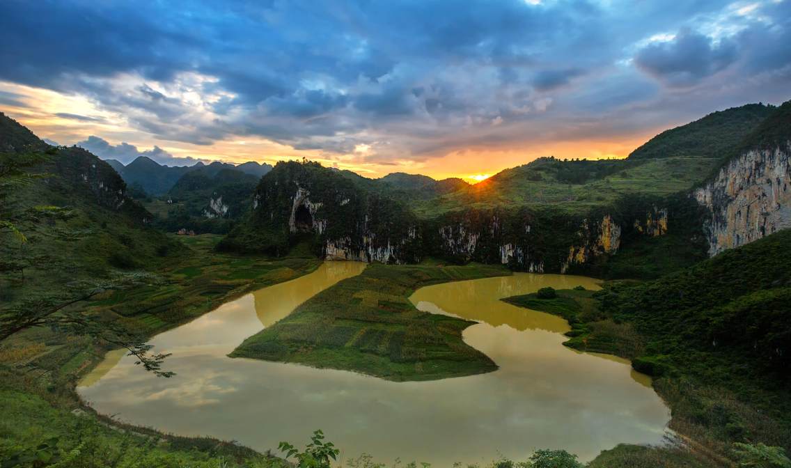 《潮起阴山》偶遇雨后转晴的凤山江洲阴阳山日落，满天乌云在夕阳的余晖中泛起诱人蓝色色谱，陪衬在阴山湿地，建立了冷暖相间动人背景，一个温馨和谐的场景瞬间被定格了。