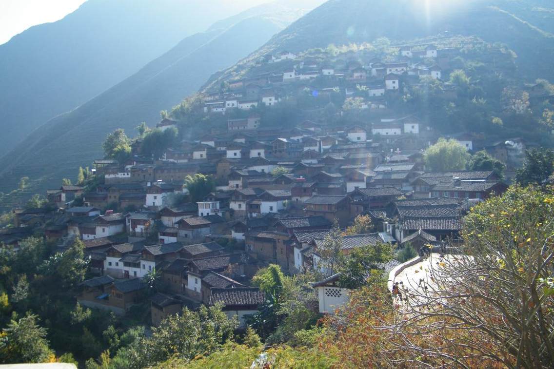 丽江宝山石头城宝山石头城，一座深藏于万山丛中神秘的纳西古城堡，坐落在玉龙雪山东北支脉牦牛内岭东麓，金沙江西岸，位于玉龙县东北部金沙江河谷，距县城126Km，地理坐标约北纬27°28′31″，东经100°10′50″。石头城初建于唐代，距今有1300多年的历史，南宋理宗保佑元年（1253），元世祖忽必烈革囊渡江，丽江土司麦良到此打开寨门引蒙古军队，留下了“元跨革囊”的千古绝唱。作为丽江古城大研镇的重要边关，宝山石头城建有一套整的防御系统，由城墙、点将台、烽火台、城门等组成。宝山石头城属于玉龙县宝山乡宝山村委会下宝山村民小组，有224户（其中城内居住着108户纳西居民）人家885人，其中纳西族880人。宝山石头城的建筑为典型的纳西族民居，多为两层木结构，以两面厦、骑楼厦等厦楼居多，因地势陡削，依石而建，“百户人家一巨一石”更是世界一绝。城内有天生岩石家具为一体的石床、石灶、石桌、石缸、石磨等，这种绝无仅有的景观为宝山石城所独有，具有很高的科学艺术价值。宝山石头城附近景点多，有“伸手摸着天，鸟飞十八天，人走一个月，猴子爬坡掉眼泪”的太子关、千奇百怪的克灵溶洞、富有传奇色彩的滴