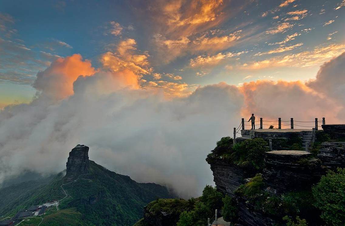 日落云海：梵净山（Mount Fanjing），原名“三山谷”，位于印江、松桃、江口的交界处，得名“梵天净土[1] ”，国务院于1986年将其确定为国家级自然保护区[2] 。梵净山乃“武陵正源，名山之宗”，曾荣膺2008年度和2009年度的“中国十大避暑名山[3] ”，是全国著名的弥勒菩萨道场，是与山西五台山、浙江普陀山、四川峨眉山、安徽九华山齐名的中国第五大佛教名山，在佛教史上具有重要的地位。[4] 梵净山是联合国人与自然保护圈成员单位之一。梵净山不仅是中国著名的弥勒菩萨道场，同时也是世界重要保护区和联合国教科文组织“人与生物圈”保护网成员之一，是中国少有的佛教道场和自然保护区两者重合的名山，成为中国佛 教文化与生态和谐共存的重要典范之一。