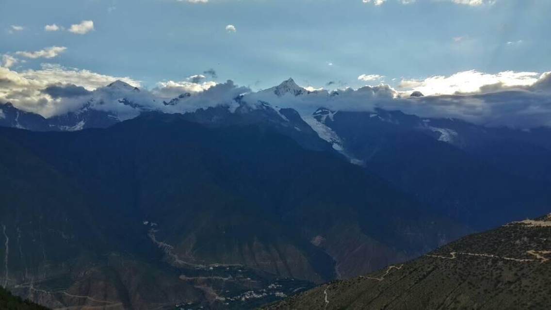 太阳刚刚没入巍峨的太子群峰，在飞来寺观景台远眺绵亘数十里的雪峰群，夕阳下的主峰卡瓦格博格外高远而神圣。